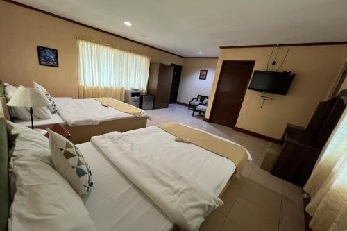 a hotel room with two beds and a flat screen tv at Vista Venice Resort in Morong