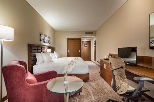 a hotel room with a bed and a tv at Hilton Garden Inn Izmir Bayrakli in Izmir