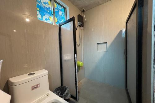 a bathroom with a shower and a toilet with a window at Vista Venice Resort in Morong