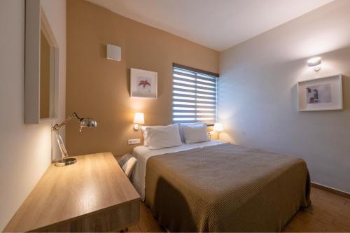 a bedroom with a bed and a table with a lamp at Linas Home - Kalamata Mediterranean Villas in Kalamata