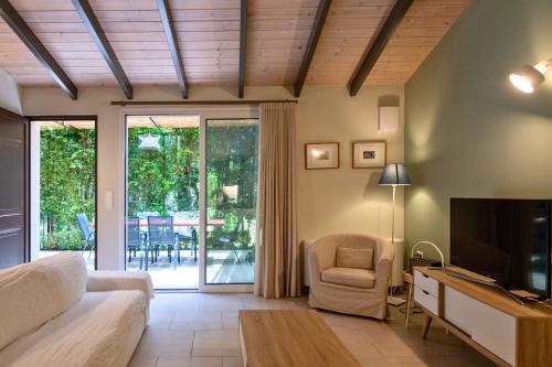 a living room with a couch and a tv at Linas Home - Kalamata Mediterranean Villas in Kalamata