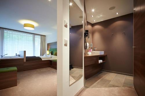 een badkamer met douche en ligbad bij Das Kronthaler - Adults only in Achenkirch