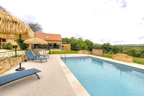 une piscine avec deux chaises à côté d'une maison dans l'établissement La Lande-Domaine de Réception-Nature-Périgord, à Groléjac