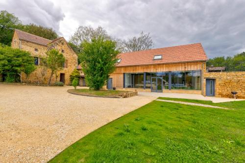 une maison avec une grande cour devant elle dans l'établissement La Lande-Domaine de Réception-Nature-Périgord, à Groléjac