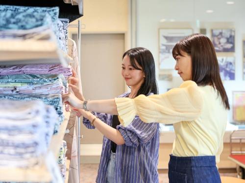 two women looking at clothes on a rack at Ikoi no mura Notohanto in Shika