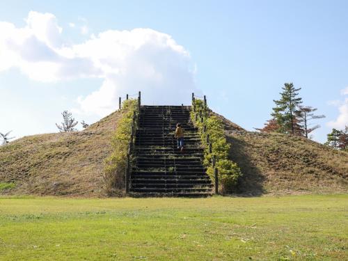 a person walking up some stairs on a hill at Ikoi no mura Notohanto in Shika
