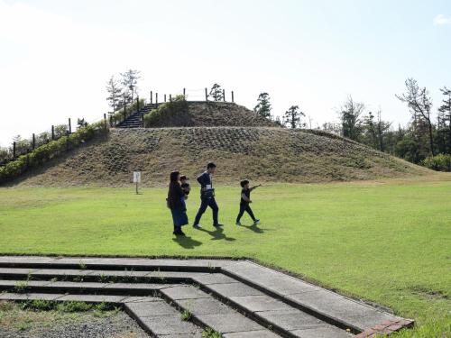 a group of people walking in a field at Ikoi no mura Notohanto in Shika