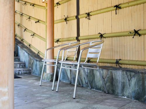 two chairs sitting in front of a wall at Ikoi no mura Notohanto in Shika