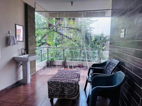 a bathroom with two chairs and a sink and a window at Vashistha Homestay in Ujjain