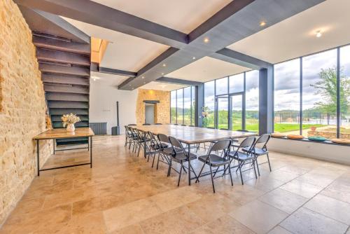 une salle à manger avec une grande table et des chaises dans l'établissement La Lande-Domaine de Réception-Nature-Périgord, à Groléjac