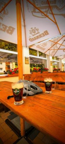 two glasses of beer sitting on a wooden table at Penzión Svätopluk v Korytnici in Liptovská Osada