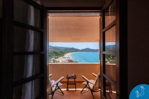 a room with a view of the beach from a window at Villa Anna - Charming dimora suspended over the sea in Geremèas