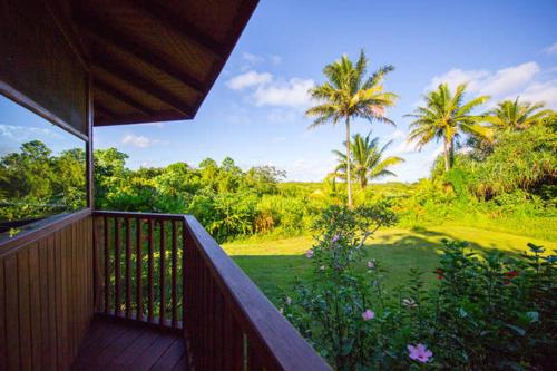 a balcony with a view of a yard with palm trees at Kirpal Meditation and Ecological Center in Pahoa