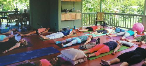 a group of people doing yoga on the floor at Kirpal Meditation and Ecological Center in Pahoa