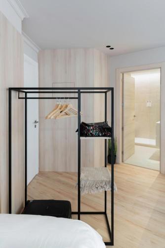 a bedroom with a bed and a black rack with shoes at Ca Gracia Bocairent in Bocairent