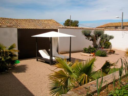 a patio with a white umbrella and a chair at Los Chicos de Lastanosa Hotel y Restaurante in Lastanosa
