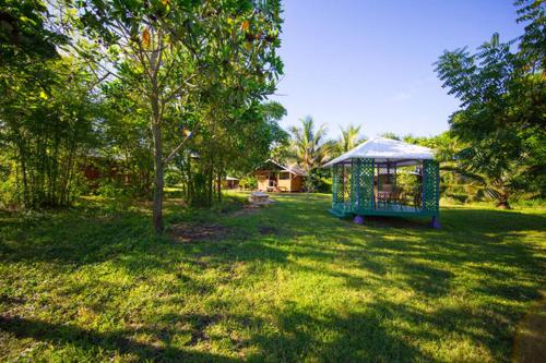 a gazebo in the middle of a yard with a tree at Kirpal Meditation and Ecological Center in Pahoa