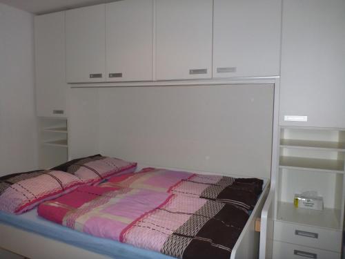 łóżko w pokoju z białymi szafkami w obiekcie Apartment Orbit Karlov P.P. w mieście Malá Morávka