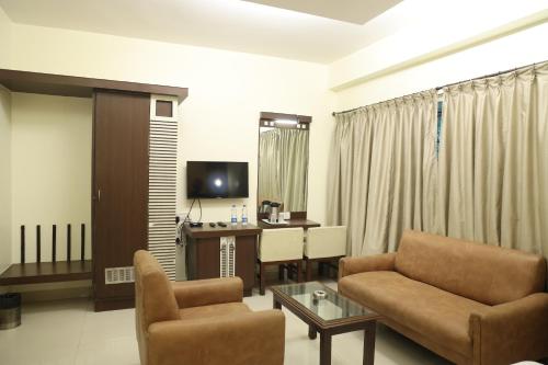 a living room with a couch and a chair and a desk at NewGoldenResidency in Bengaluru
