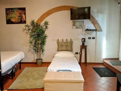 a room with two beds and a flat screen tv at La Porta Rossa in San Casciano in Val di Pesa