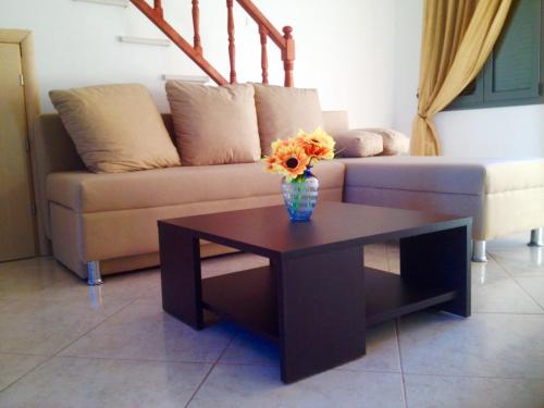 a living room with a couch and a table with flowers at Nitelli's Houses in Skála Néon Kydonión
