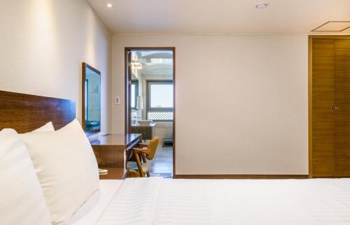 Postel nebo postele na pokoji v ubytování Uni Hotel Jeju