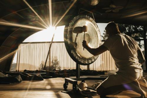 a man playing a drum in a room at Acro Suites - A Wellbeing Resort in Agia Pelagia