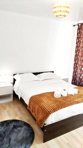 a bedroom with a bed with white sheets and a rug at Méditerranée in Cherbourg en Cotentin
