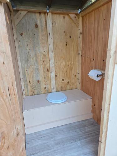 a bathroom with a toilet in a wooden cabin at Highway HotTub Hideaway Bunkbed sleeps two in Tok