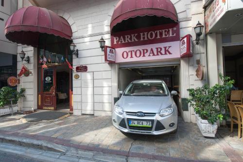 um pequeno carro estacionado em frente a uma loja em Oglakcioglu Park Boutique Hotel em Esmirna