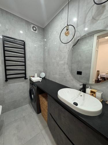 Un baño con lavabo y lavadora. en Kobylianska Apartments, en Chernivtsi