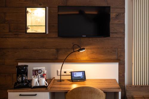 a desk with a television and a laptop on it at Dorint Strandresort & Spa Ostseebad Wustrow in Wustrow