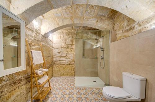a stone bathroom with a toilet and a shower at Ta' Zaren Townhouse, Siggiewi in Siġġiewi