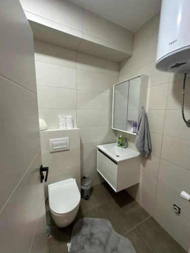 a white bathroom with a toilet and a sink at Pristina Luxury Apartments 15 in Pristina