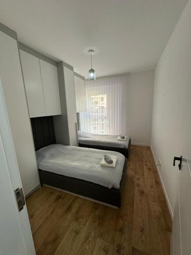 a small bedroom with two beds and a window at Pristina Luxury Apartments 15 in Pristina