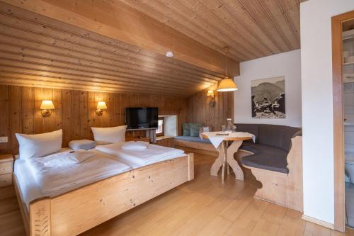 a bedroom with a large bed and a desk at Beim Nuihausa in Reit im Winkl