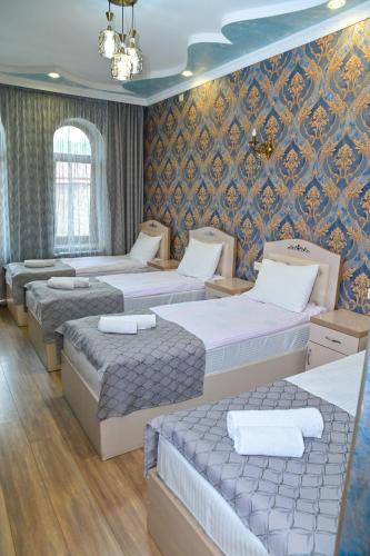a room with four beds and a wall at Har-Mar Hotel in Goris
