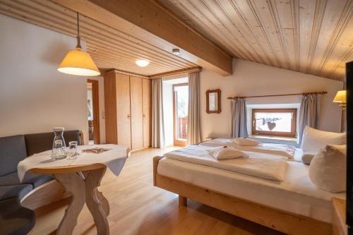 a bedroom with a large bed and a table at Beim Nuihausa in Reit im Winkl