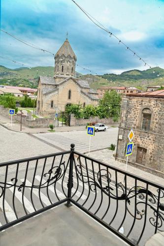 a view from a balcony of a building with a church at Har-Mar Hotel in Goris