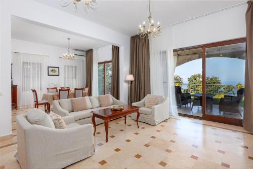a living room with white furniture and a table at Oak Leaf Residences in Budva