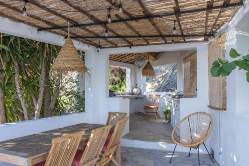 a patio with a wooden table and chairs at U Munticellu - Piscine vue mer in Monticello