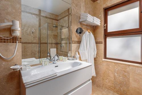 a bathroom with a sink and a shower and a window at Oak Leaf Residences in Budva