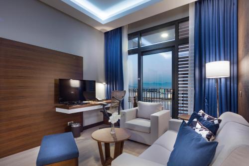 a living room with a white couch and a tv at Hilton Garden Inn Izmir Bayrakli in Izmir