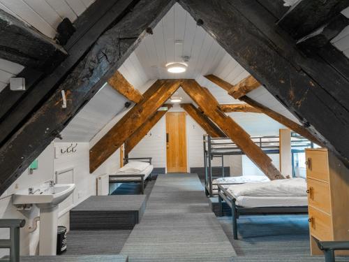 an attic room with four beds and a sink at YHA Hartington Hall in Hartington