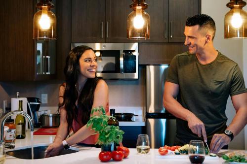 a man and woman standing in a kitchen preparing food at Residence Inn by Marriott Santa Barbara Goleta in Santa Barbara