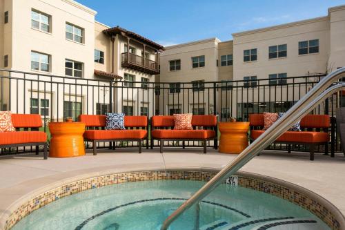 a patio with chairs and a pool in a building at Residence Inn by Marriott Santa Barbara Goleta in Santa Barbara