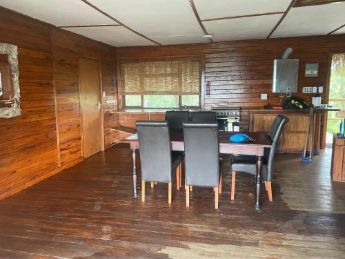 a dining room with a wooden table and chairs at Izmaan Lodge Pomene in Fombeni