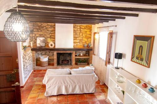 a living room with a couch and a fireplace at Finca Tossalet. Piscina privada y barbacoa in Benissa