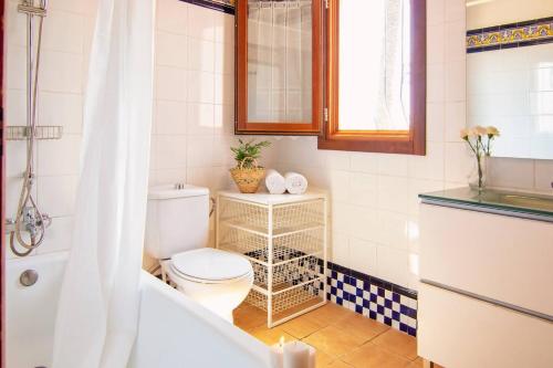 a bathroom with a toilet and a bath tub at Finca Tossalet. Piscina privada y barbacoa in Benissa