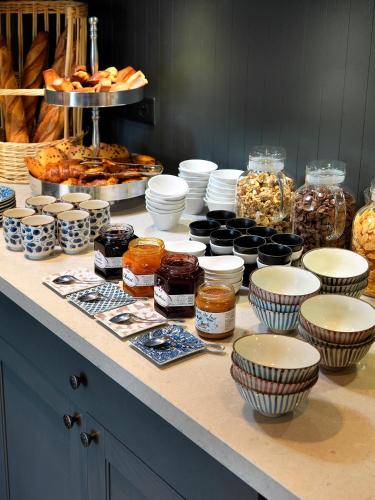 a counter with bowls and other food items on it at Hôtel Beau Site Talloires B SPA in Talloires